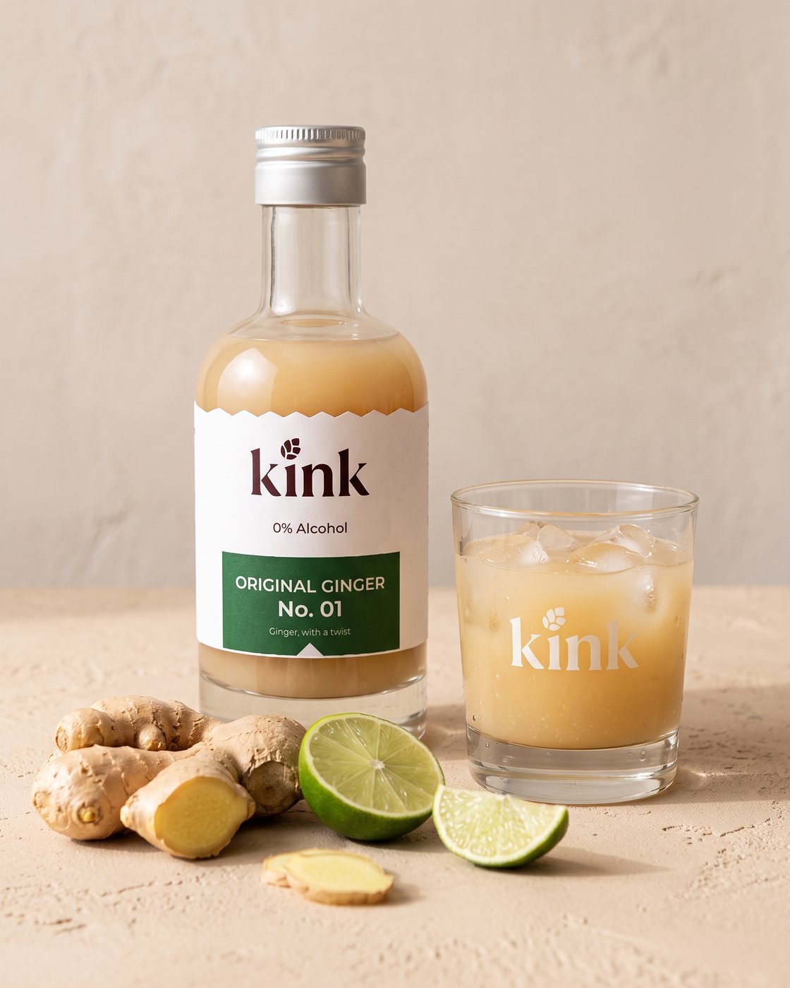 kink 210ml bottle beside a glass of kink over ice, with fresh ginger and lime